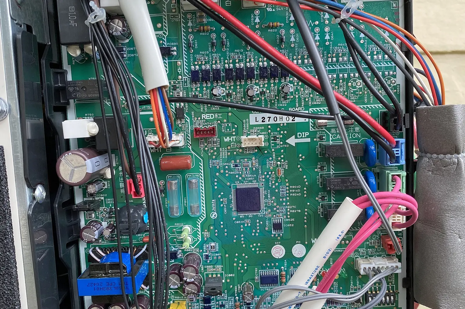 Heat pump control board with wiring harnesses exposed for diagnosis