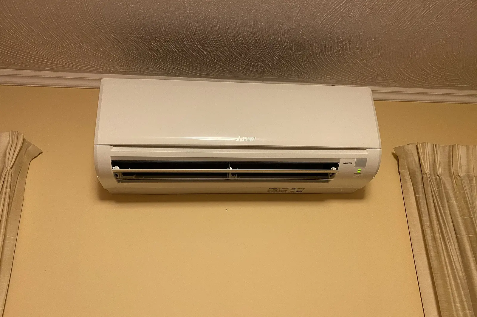 Ductless mini-split indoor head mounted high on a bedroom wall